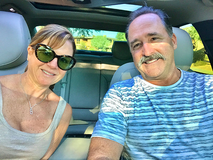 Smiling couple sitting in car before road trip