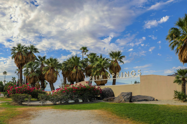 palm springs welcome sign with palm trees in the background