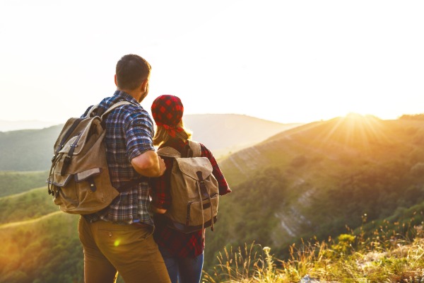 couple on the top of a mountain after hiking at sunset